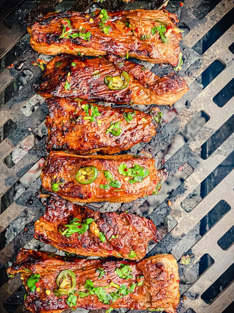 flap steaks cooking on a hot grill