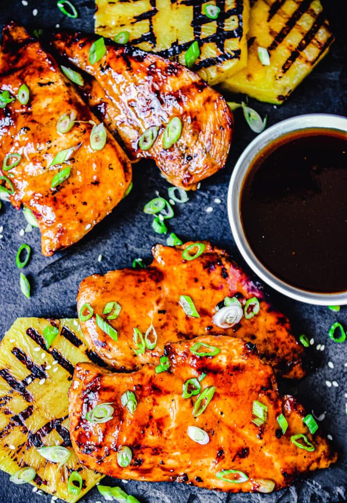 overhead view of huli huli chicken thighs and grilled pineapple