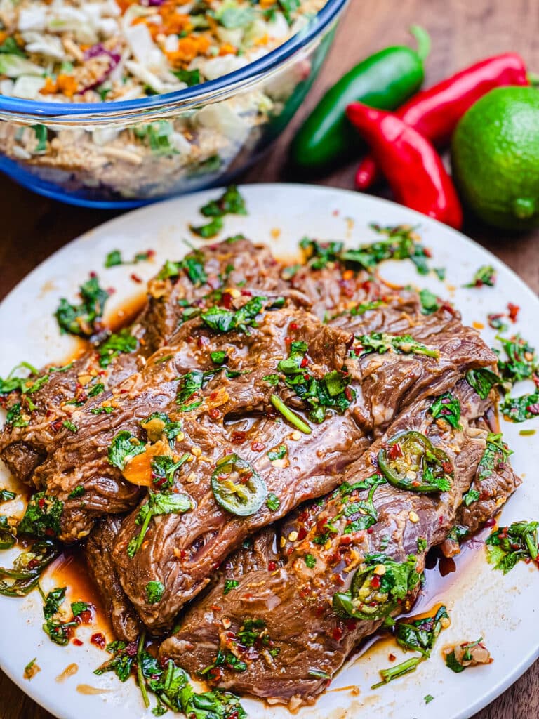 beef covered in marinade on a white plate