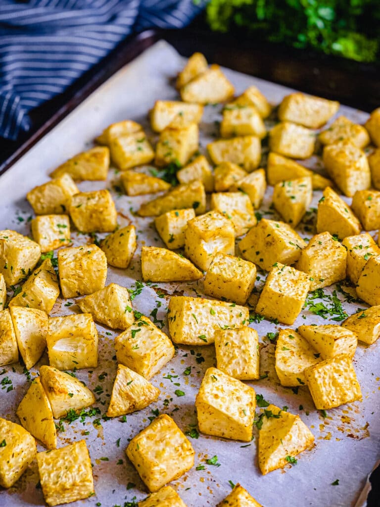 Roasted celery root on a baking sheet with parsley