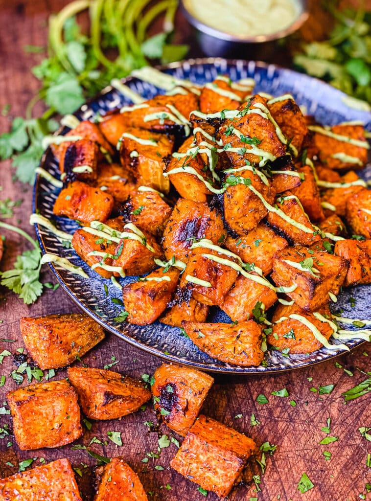 blue plate piled with roasted sweet potato cubes