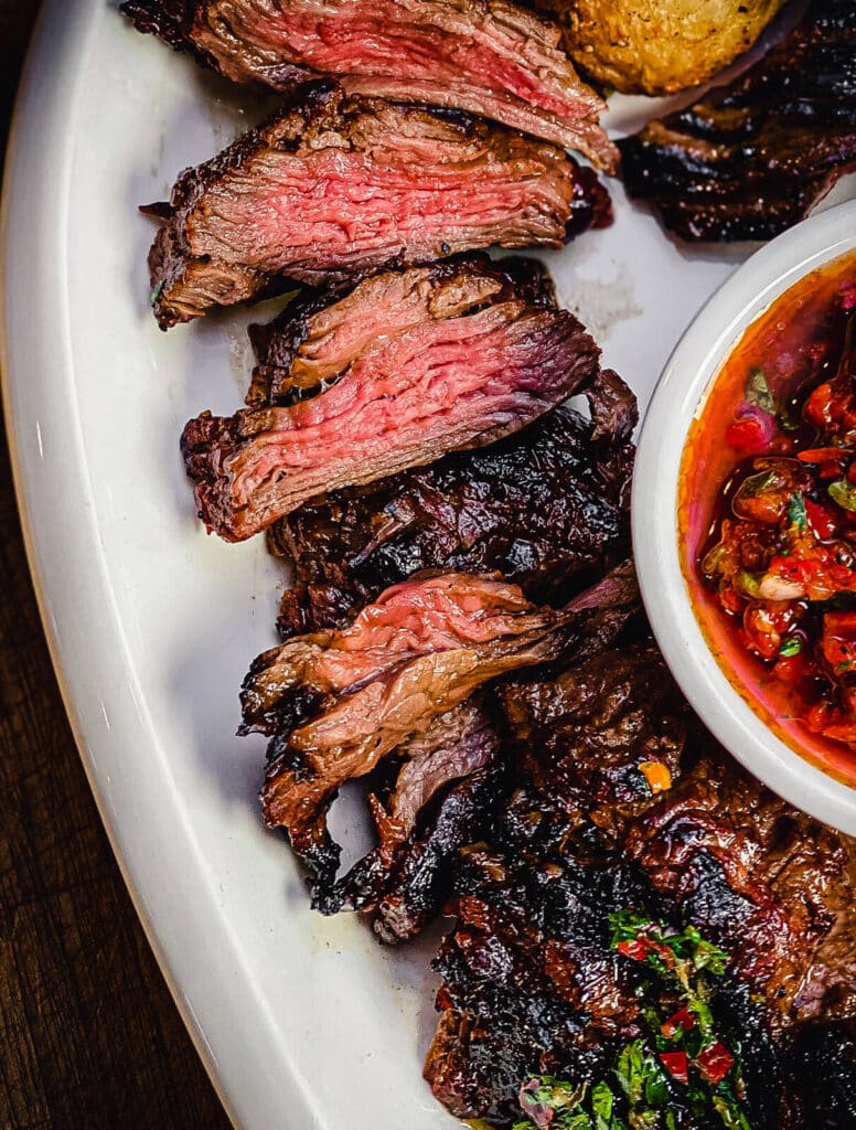 skirt steak sliced on a platter cooked to medium rare