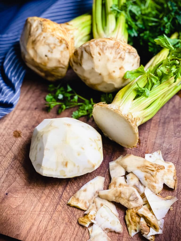 celery root being trimmed on a cutting board