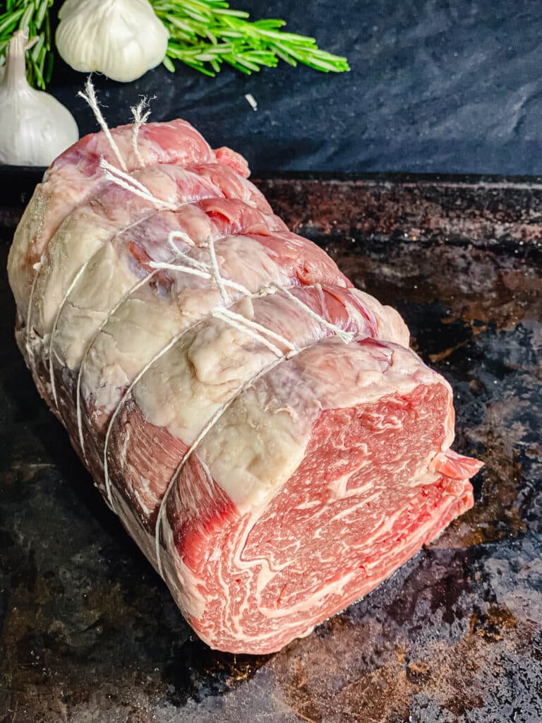 prime rib roast tied into a cylinder shape with butcher's twine