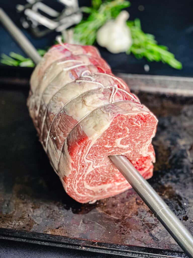 prime rib roast on a rotisserie spit