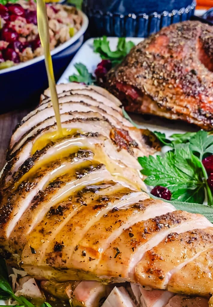 pouring brown sage butter onto a roasted turkey