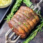 rotisserie prime rib on a spit, sitting on a baking sheet