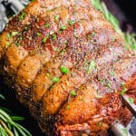 cooked rotisserie prime rib on a spit with rosemary