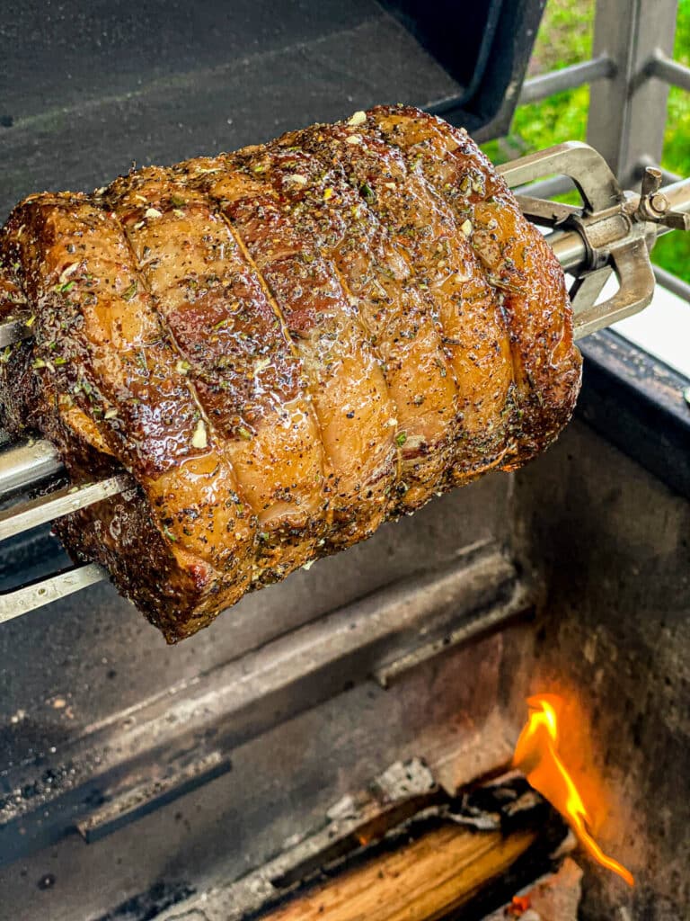 beef roasting over a fire on the grill