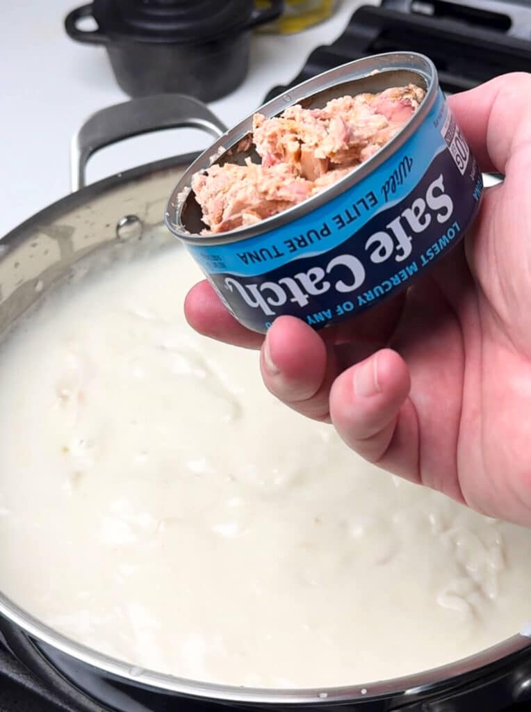 can of tuna about to be added into a cream sauce