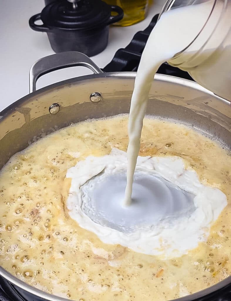 milk being added to a cream sauce