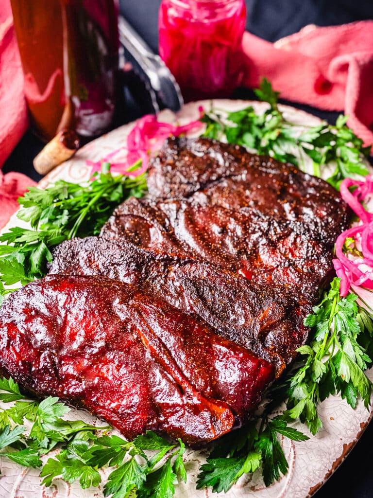 platter of barbecue pork shoulder steaks with red onions