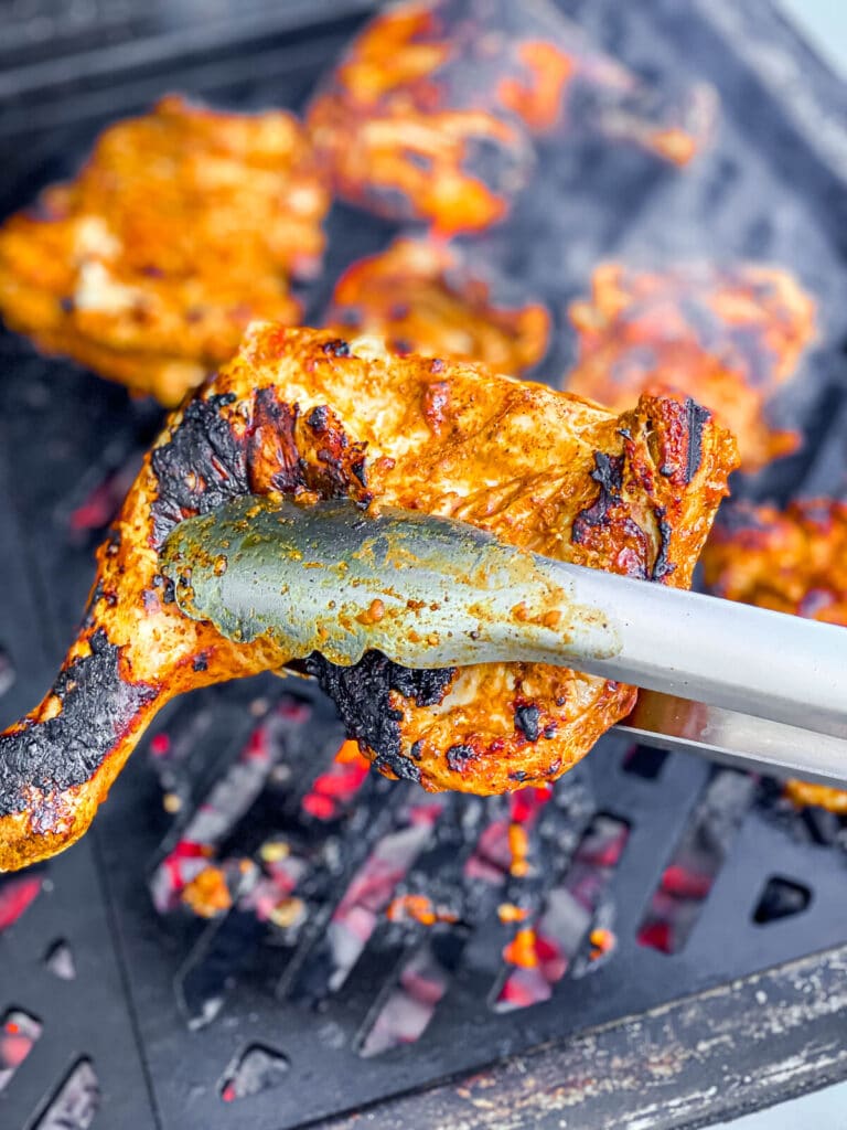 pollo asado chicken being grilled over hot coals