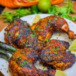 pollo asado on a plate with limes and cilantro