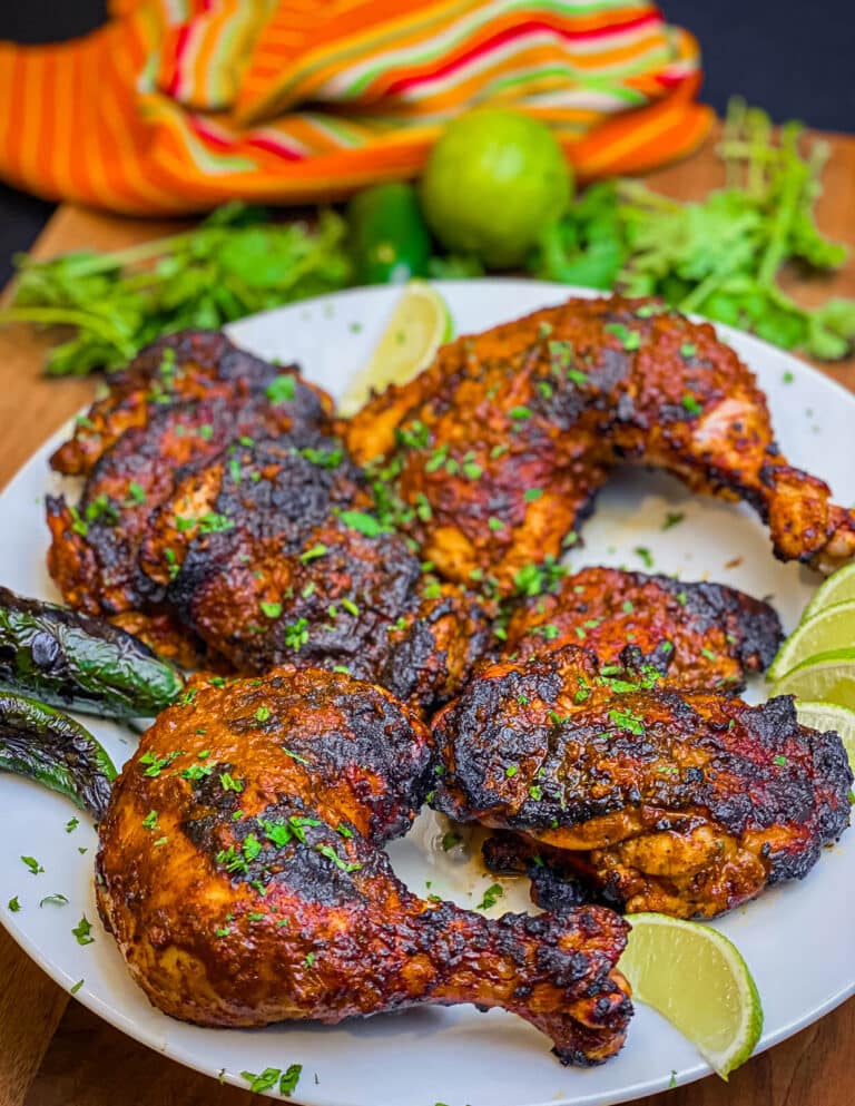 pollo asado on a plate with limes and cilantro