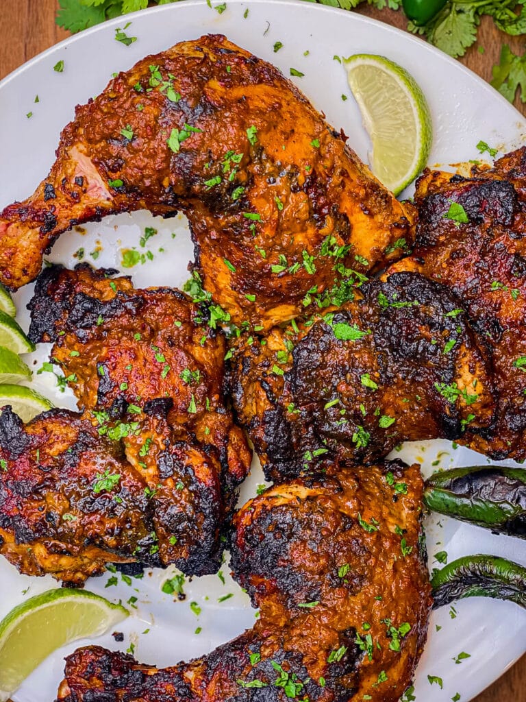 overhead shot of pollo asado on a white plate