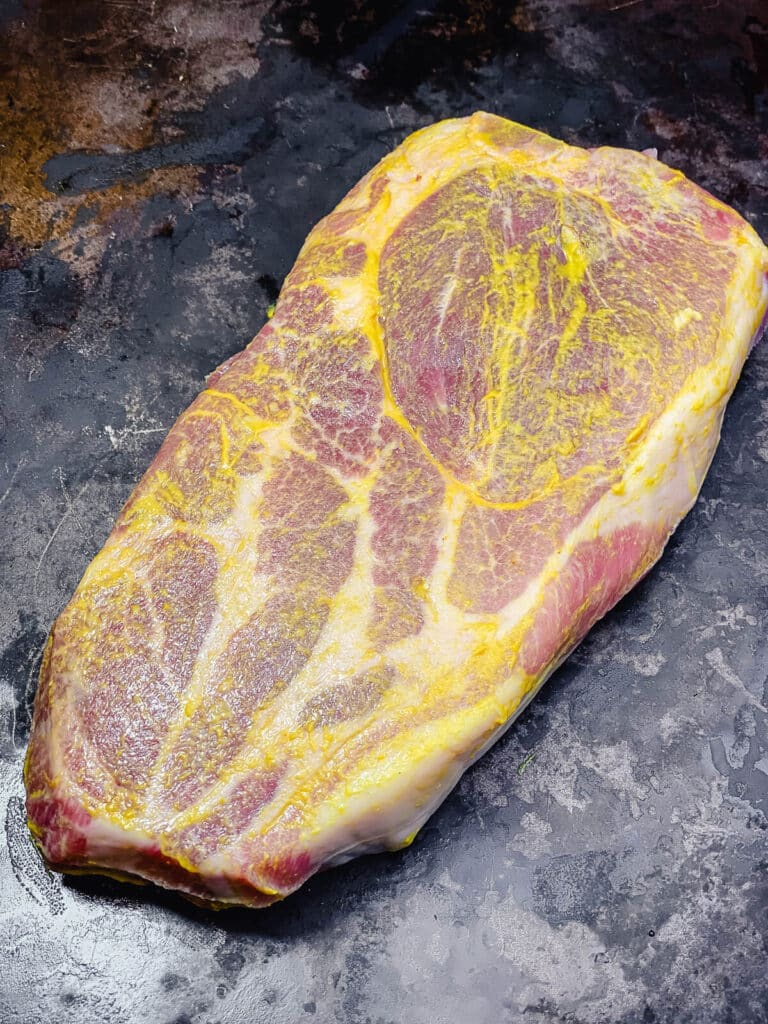 mustard coating on a thick cut piece of pork