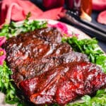 pork steaks on a platter with bbq sauce and fresh herbs