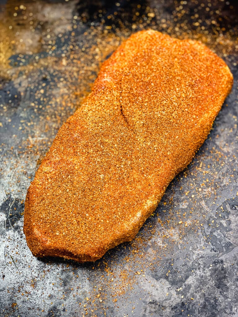 seasoned pork steak on a tray