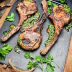 black slate cutting board with tomahawk pork chops and herbs