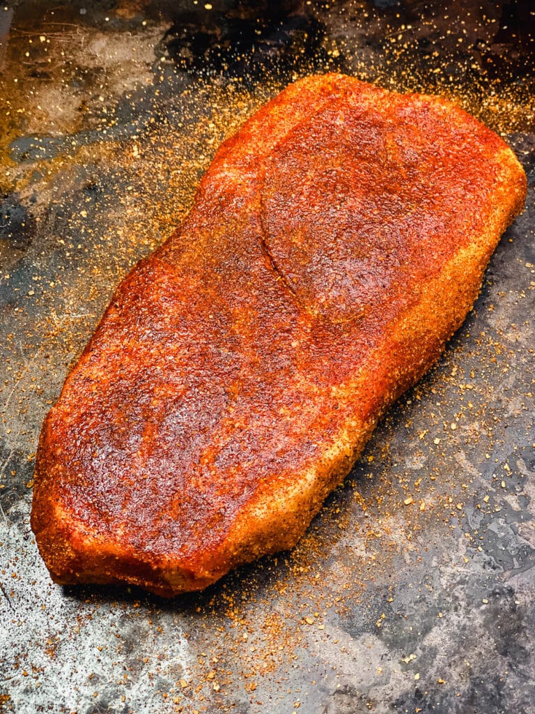 seasoned pork steak on a baking sheet