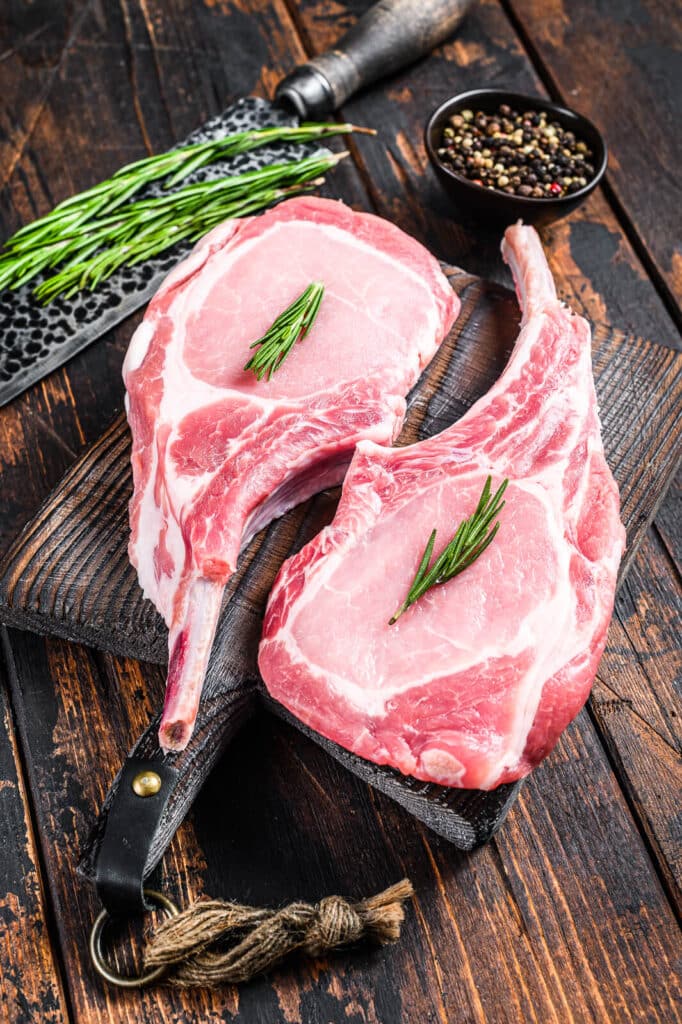 uncooked pork chops on a cutting board