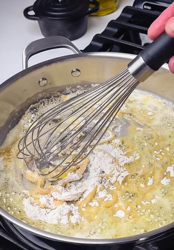 flour being whisked into melted butter 