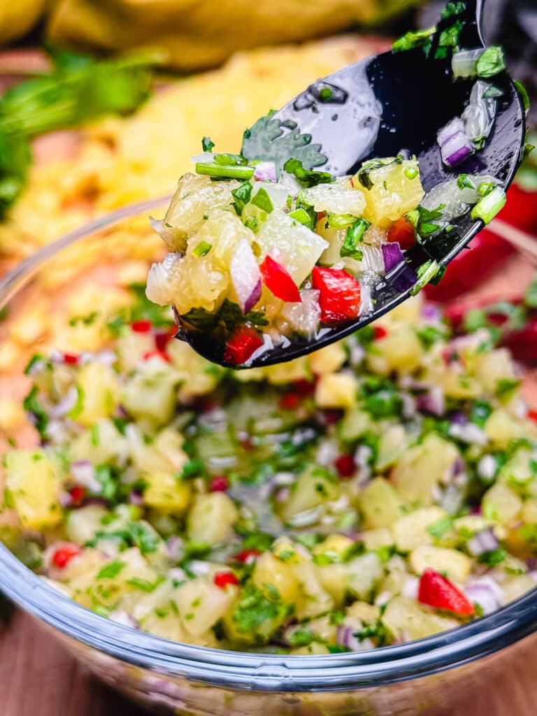 bright colored fruit on a black spoon over a bowl