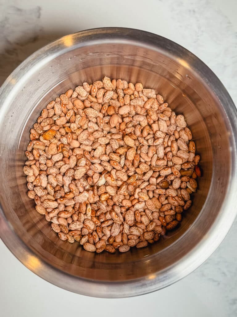 water covering dried beans in a bowl