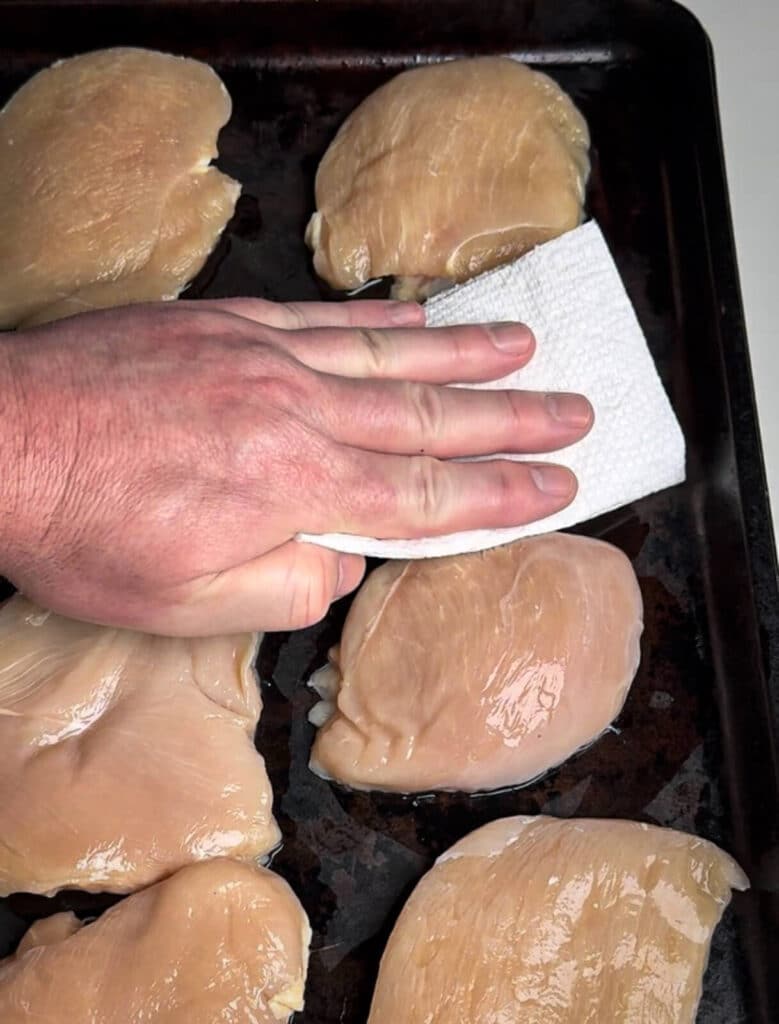 drying off chicken breasts with papertowel