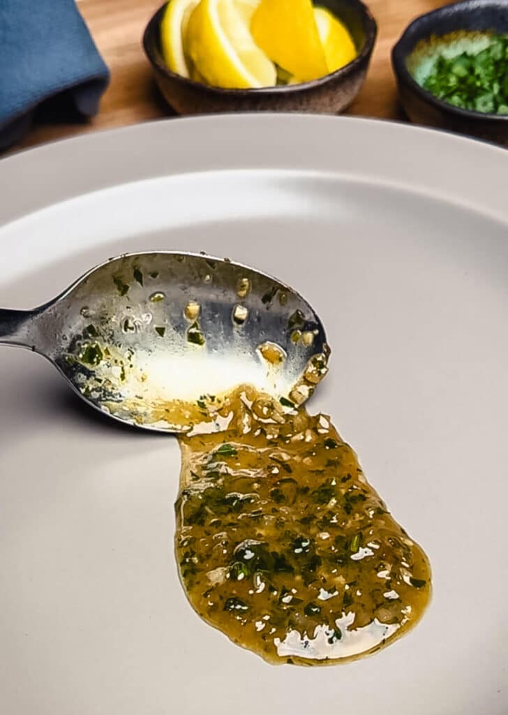chicken pan sauce being added to a plate