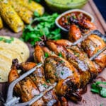 rotisserie grilled Cornish hens sitting on a cutting board