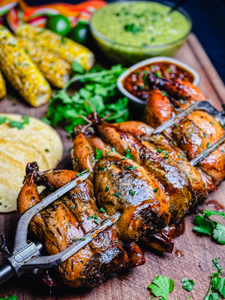 rotisserie grilled Cornish hens sitting on a cutting board