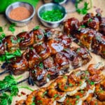 chicken and bacon skewers with grilled shrimp on a cutting board