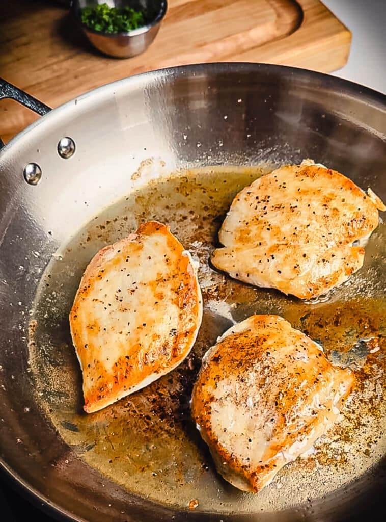 chicken breast browned in a steel pan