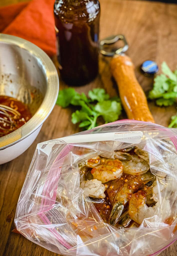 shrimp in a zip top bag covered with sweet chili sauce