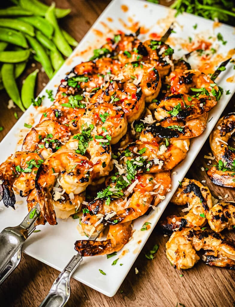 white platter with sweet chili shrimp on skewers
