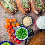 taco dogs on a platter with tomatoes and chili