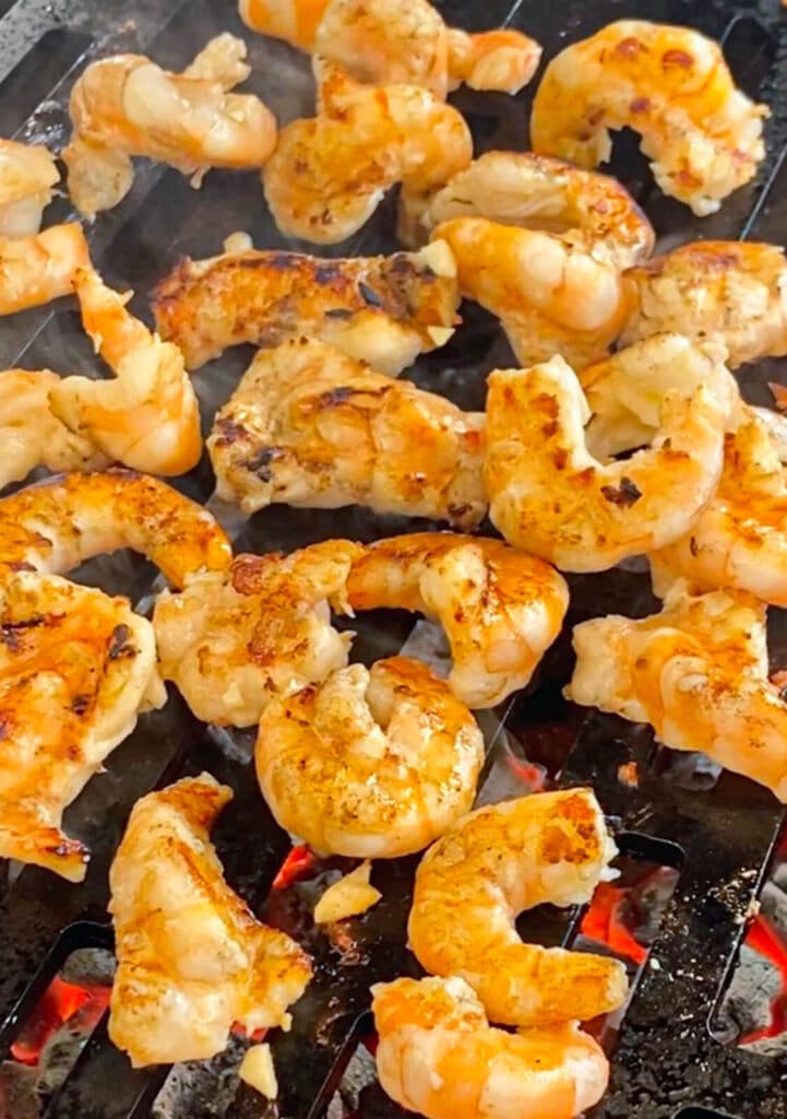 shrimp being grilled over a fire on a grill