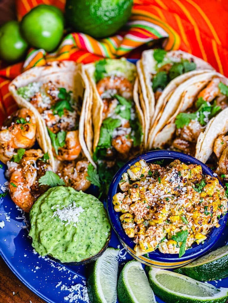tequila lime shrimp tacos with lime wedges and corn
