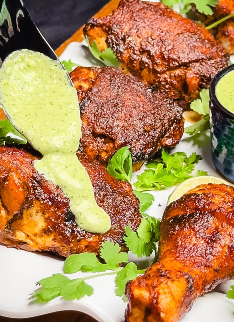 aji verde sauce being spooned over peruvian chicken