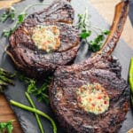 pads of bacon butter on top of charred ribeye steaks