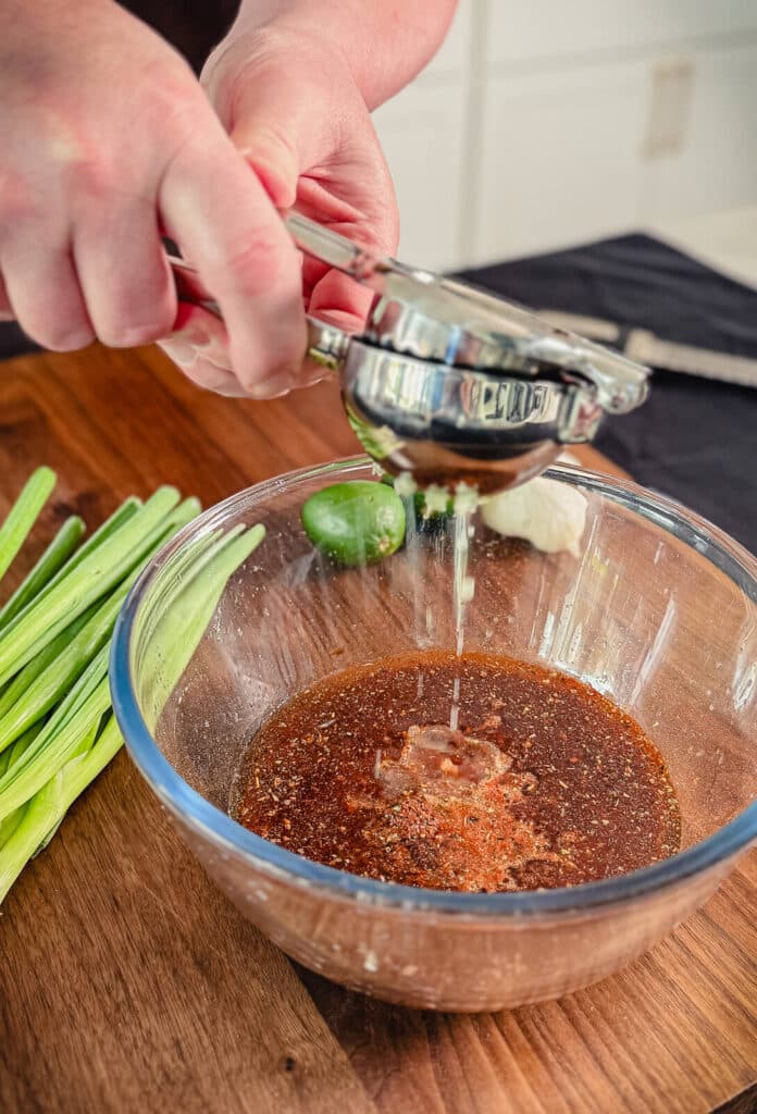 Lime juice being squeezed into a Peruvian marinade