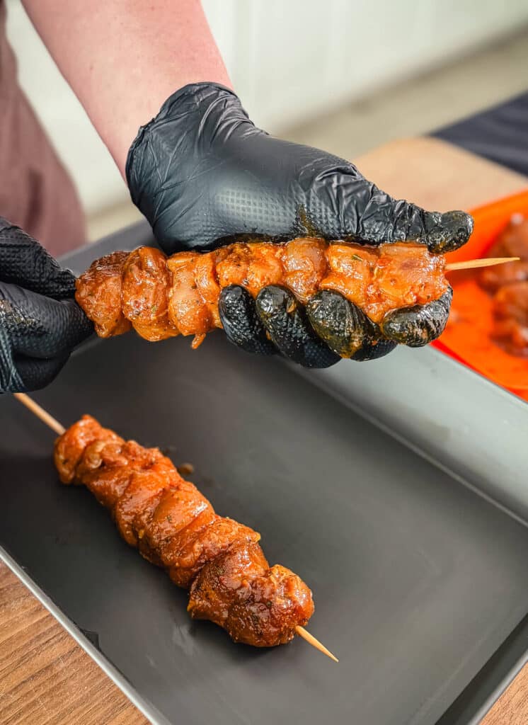 chicken skewer being shaped with a gloved hand