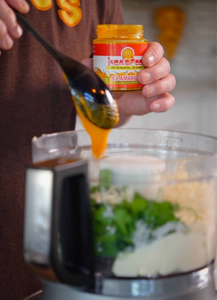 aji amarillo paste being added to a food processor