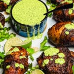bowl of aji verde sauce with limes and cilantro