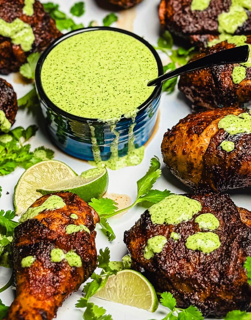 bowl of aji verde sauce with limes and cilantro