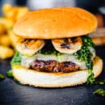 columbian burger with grilled bananas on a black cutting board