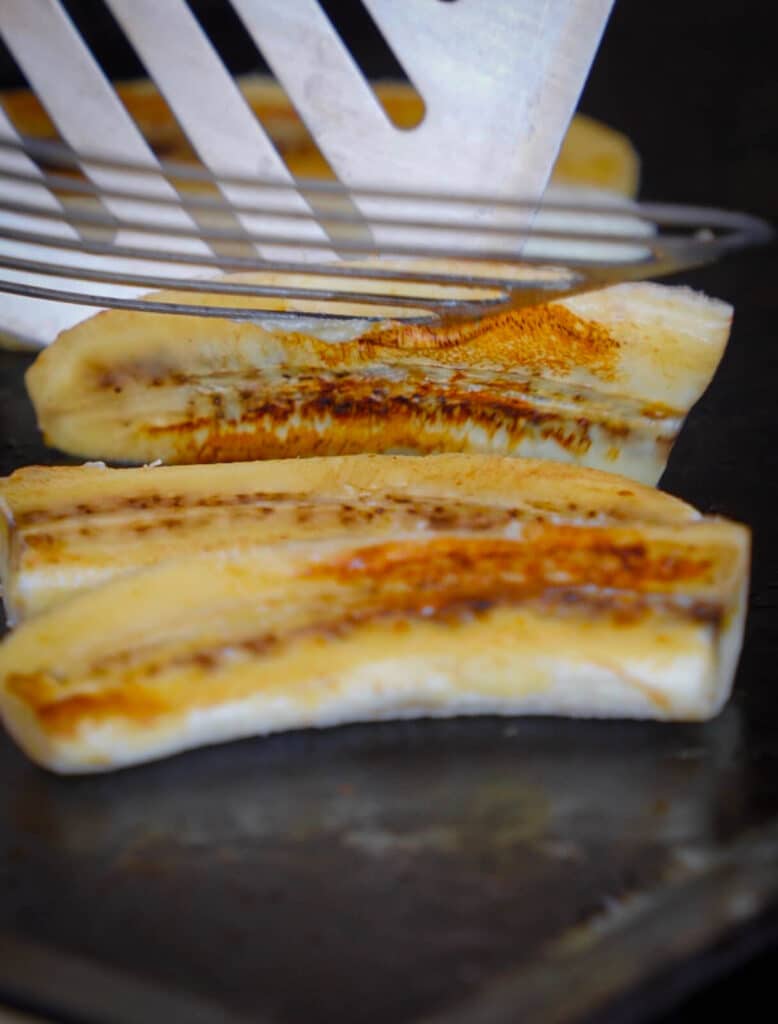 bananas being seared on a griddle top surface