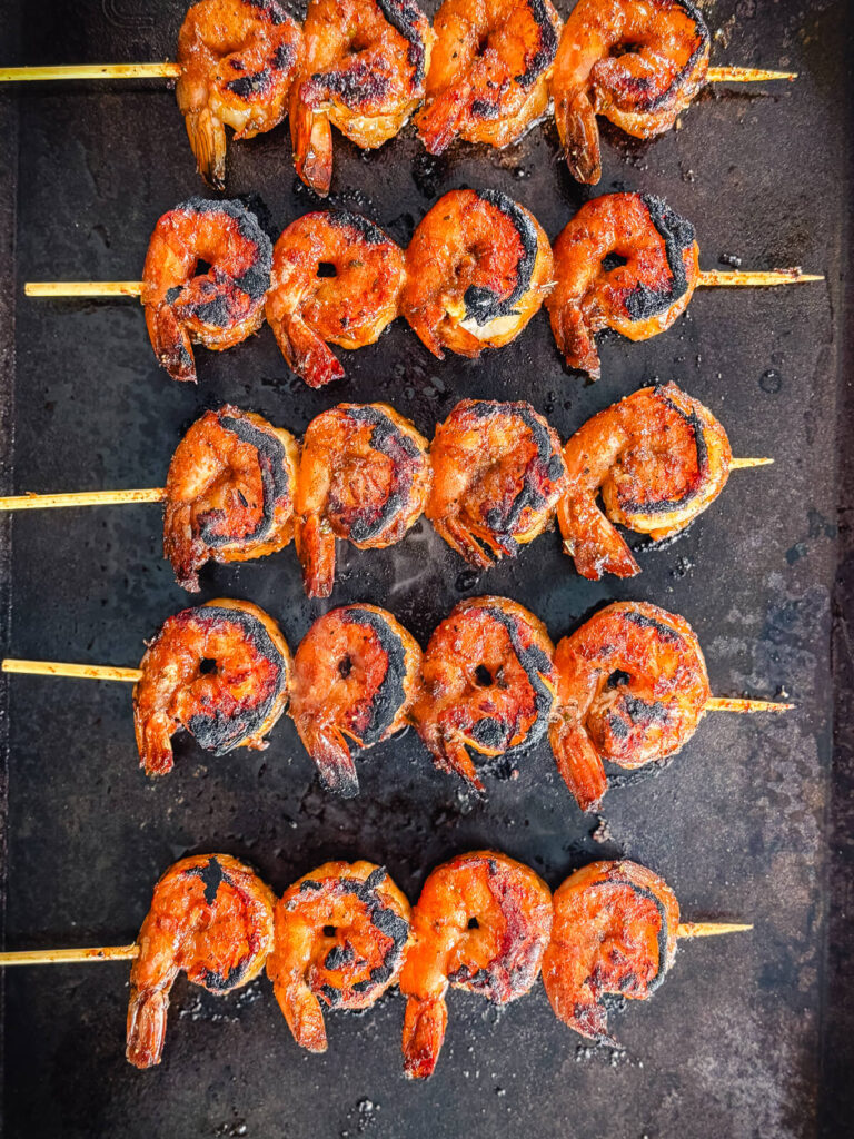 seared peruvian shrimp skewers on a griddle surface